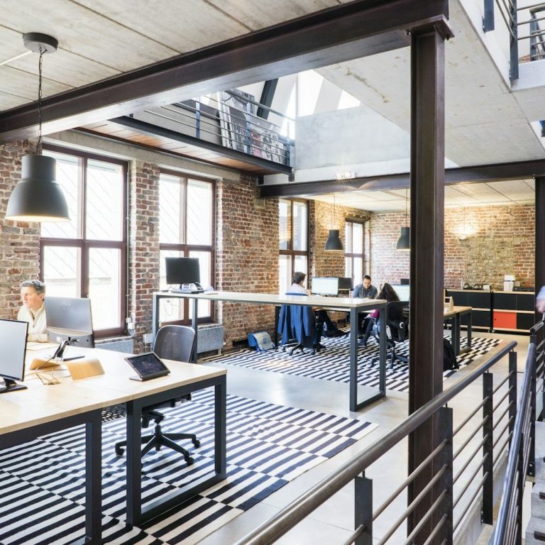Bureau moderne avec des bureaux, chaises et une décoration intérieure éclairée.