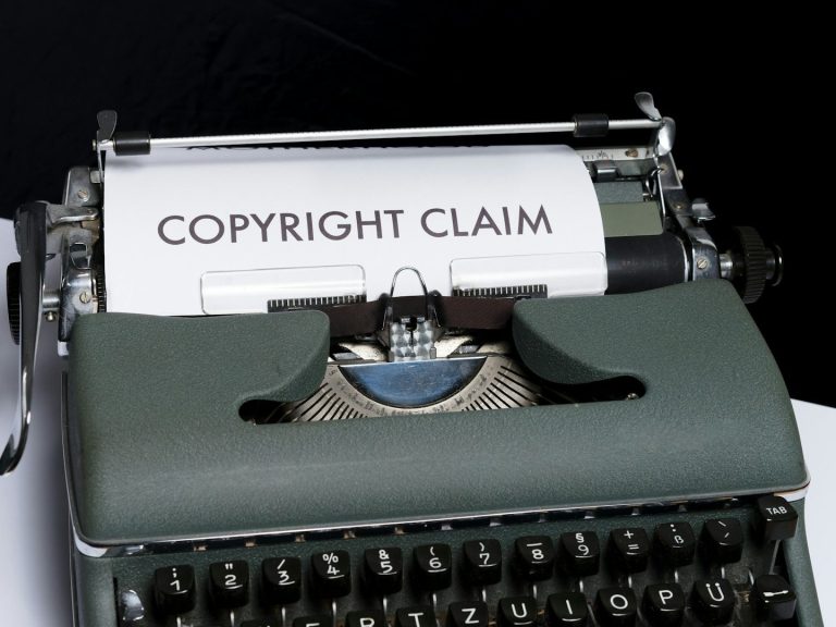 Machine à écrire vintage avec "COPYRIGHT CLAIM" écrit sur la page.