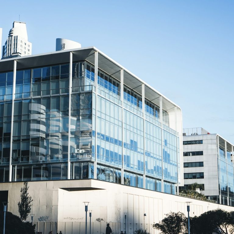 Bâtiment moderne en verre avec un ciel bleu en arrière-plan.