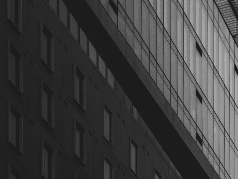 Façade d'un immeuble moderne, avec des fenêtres et des lignes géométriques.